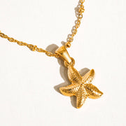 Gold starfish pendant necklace on a white background